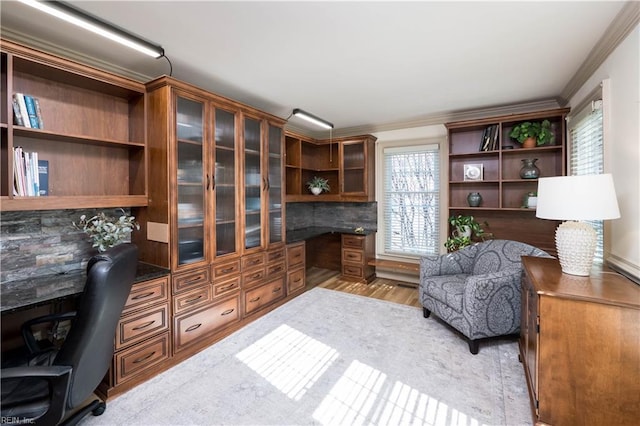 office area featuring ornamental molding, built in desk, and light hardwood / wood-style floors