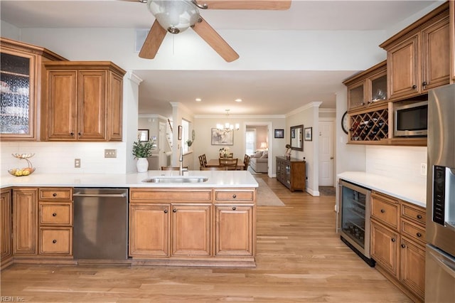 kitchen with sink, stainless steel appliances, wine cooler, tasteful backsplash, and light wood-type flooring