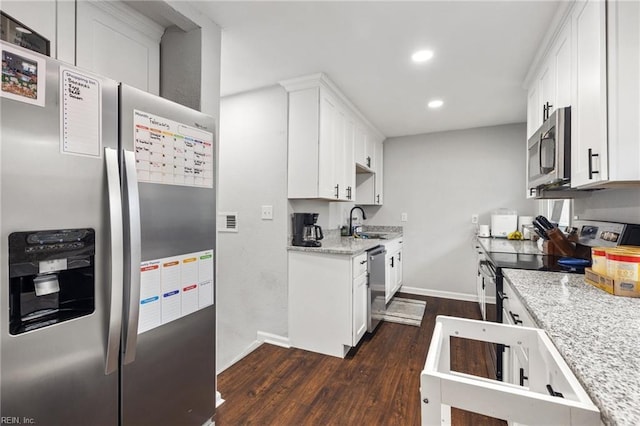 kitchen with sink, appliances with stainless steel finishes, white cabinetry, dark hardwood / wood-style floors, and light stone counters