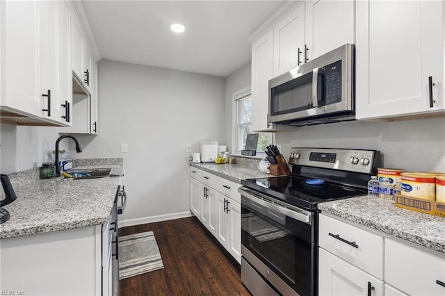 kitchen featuring light stone counters, stainless steel appliances, sink, and white cabinets