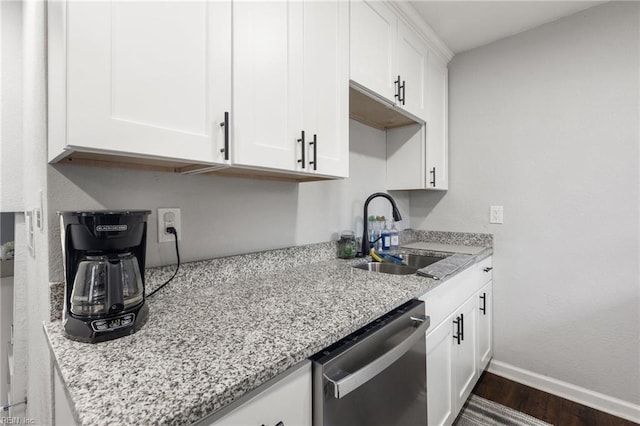 kitchen featuring sink, light stone counters, dark hardwood / wood-style floors, dishwasher, and white cabinets