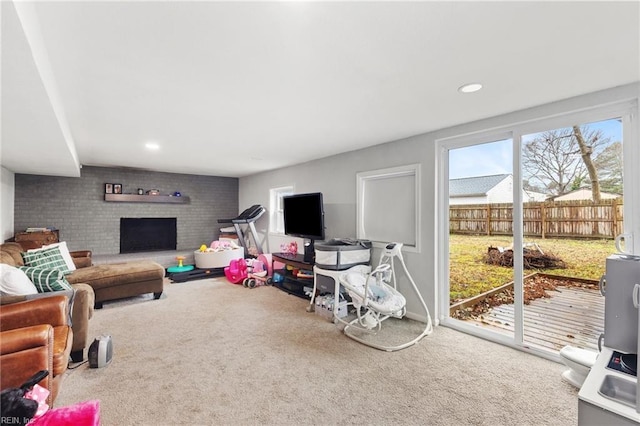 recreation room featuring carpet floors and a brick fireplace