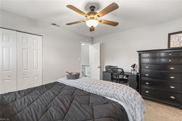 bedroom featuring ceiling fan, light colored carpet, and a closet