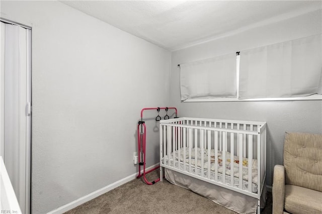 bedroom with a crib, carpet, and a closet