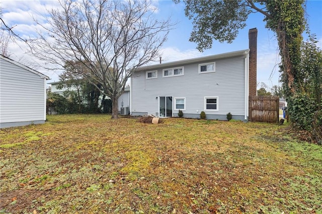 back of house with central AC and a lawn