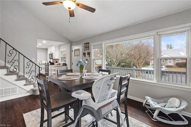 dining space with dark wood-type flooring, ceiling fan, and vaulted ceiling