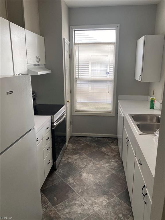 kitchen with white cabinetry, sink, stainless steel range with electric cooktop, and white fridge