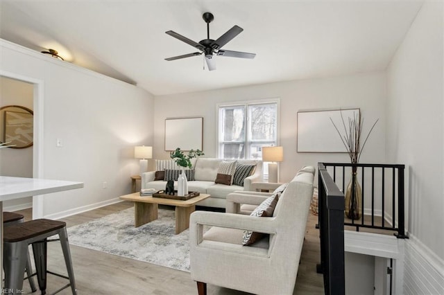 living room with hardwood / wood-style flooring, vaulted ceiling, and ceiling fan