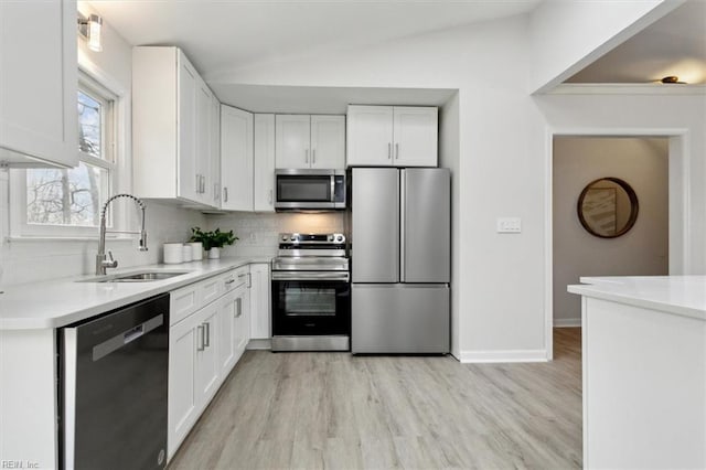 kitchen with sink, white cabinetry, tasteful backsplash, light hardwood / wood-style flooring, and appliances with stainless steel finishes