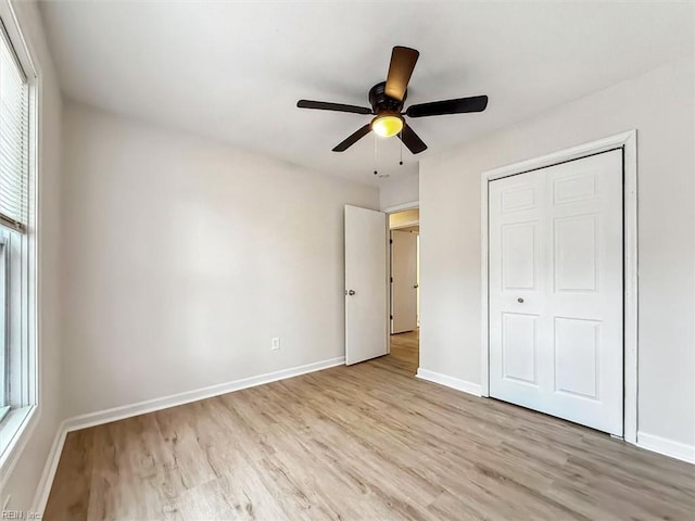 unfurnished bedroom with ceiling fan, light hardwood / wood-style floors, and multiple windows