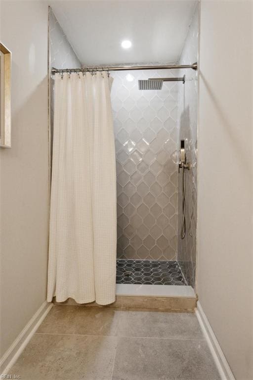 bathroom with curtained shower and tile patterned flooring