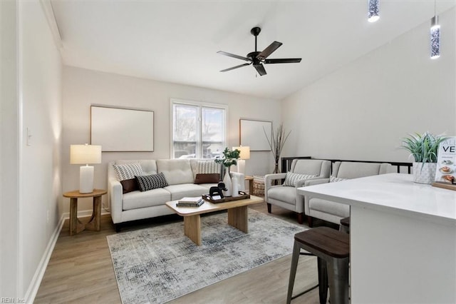 living room with ceiling fan, lofted ceiling, and light hardwood / wood-style floors