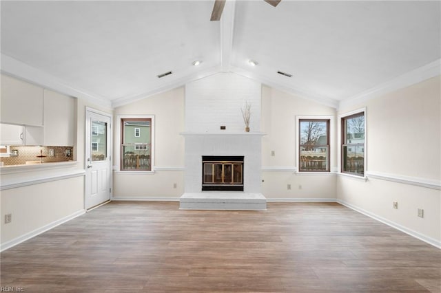 unfurnished living room featuring light hardwood / wood-style flooring, vaulted ceiling with beams, a fireplace, and ceiling fan