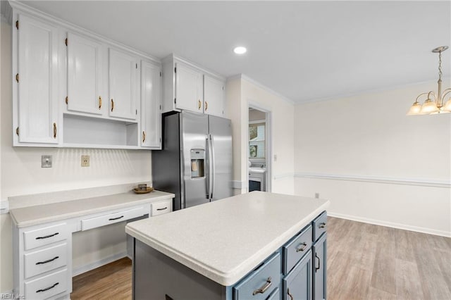 kitchen with pendant lighting, white cabinetry, stainless steel fridge, a center island, and light wood-type flooring