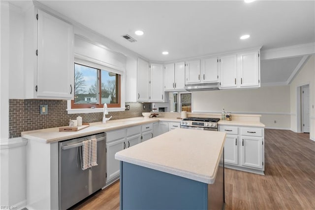 kitchen with a kitchen island, white cabinetry, sink, stainless steel appliances, and light hardwood / wood-style flooring