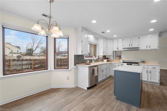 kitchen featuring decorative light fixtures, white cabinetry, hardwood / wood-style flooring, a center island, and stainless steel dishwasher