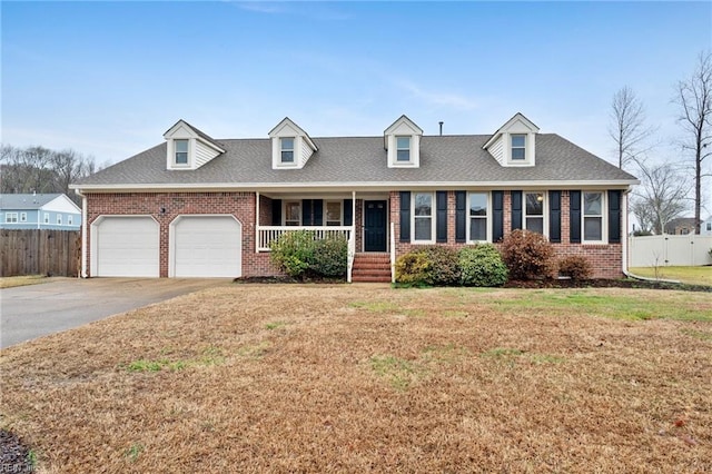 new england style home with a garage, a porch, and a front yard