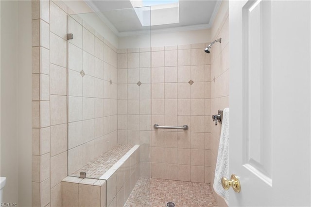 bathroom featuring crown molding and a tile shower