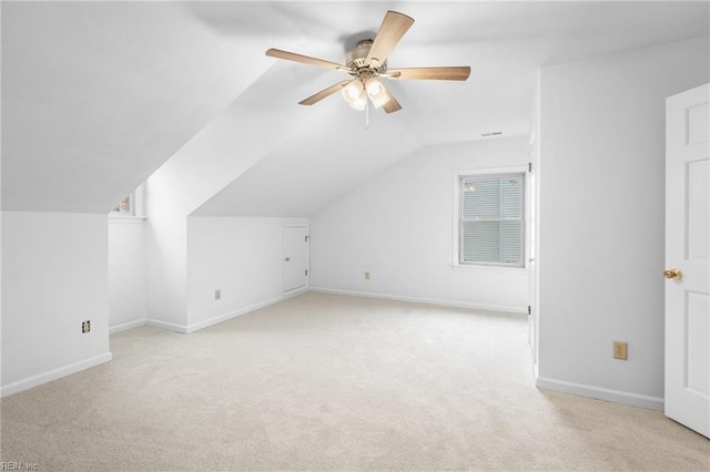 additional living space featuring light carpet, lofted ceiling, and ceiling fan