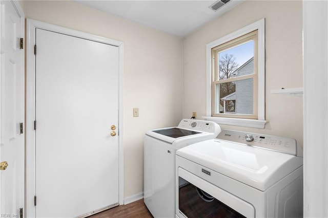 clothes washing area featuring separate washer and dryer and dark wood-type flooring