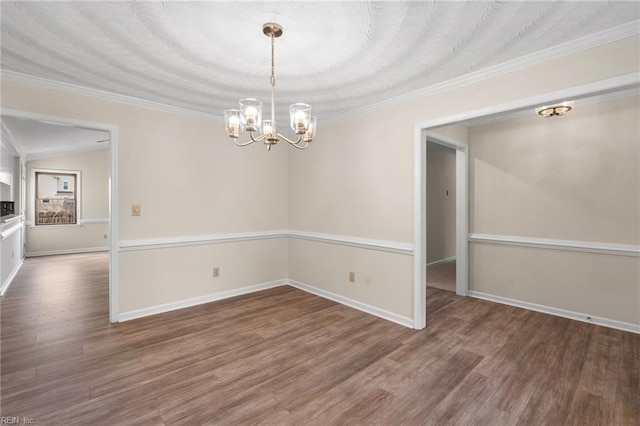 empty room featuring an inviting chandelier, lofted ceiling, dark hardwood / wood-style flooring, and crown molding