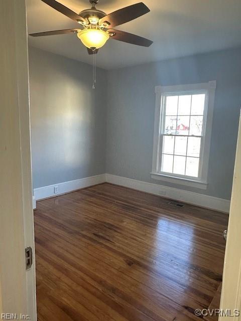 empty room with dark hardwood / wood-style floors and ceiling fan