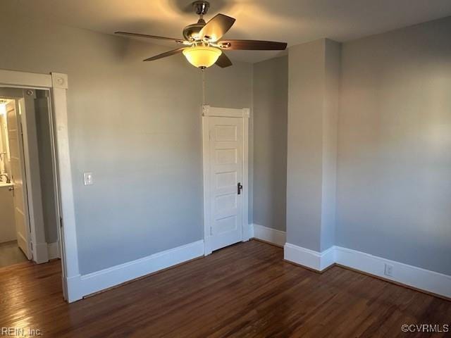 empty room with dark hardwood / wood-style floors and ceiling fan