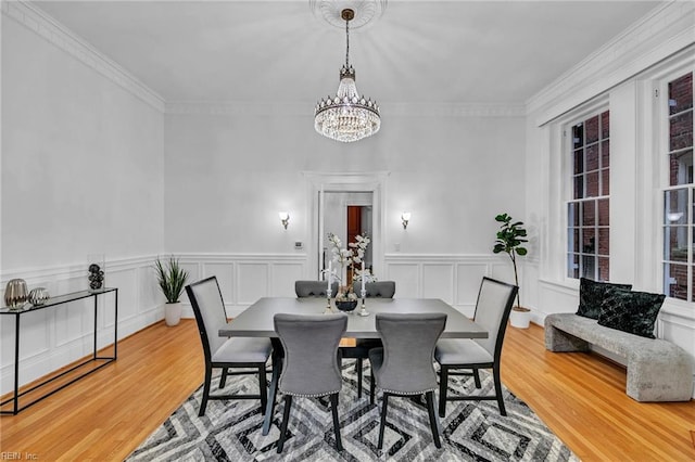 dining area featuring an inviting chandelier, crown molding, and hardwood / wood-style floors