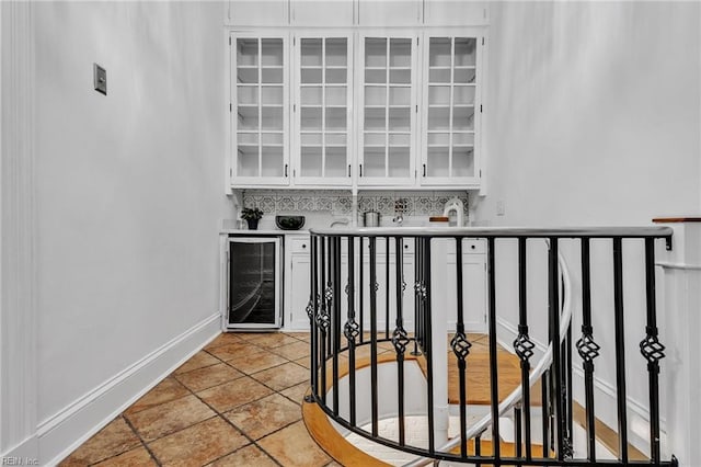 bar with white cabinetry, beverage cooler, and decorative backsplash