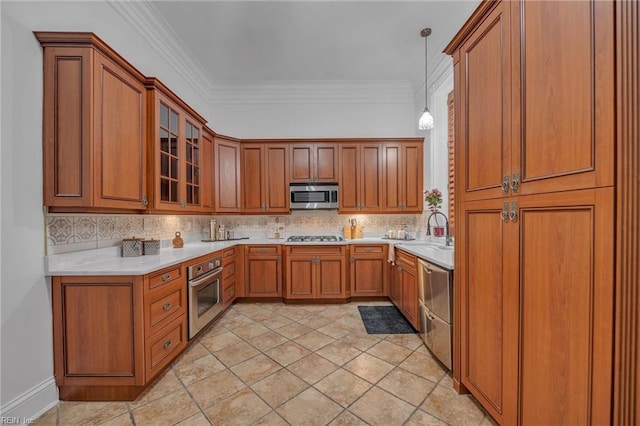 kitchen featuring appliances with stainless steel finishes, sink, backsplash, and decorative light fixtures