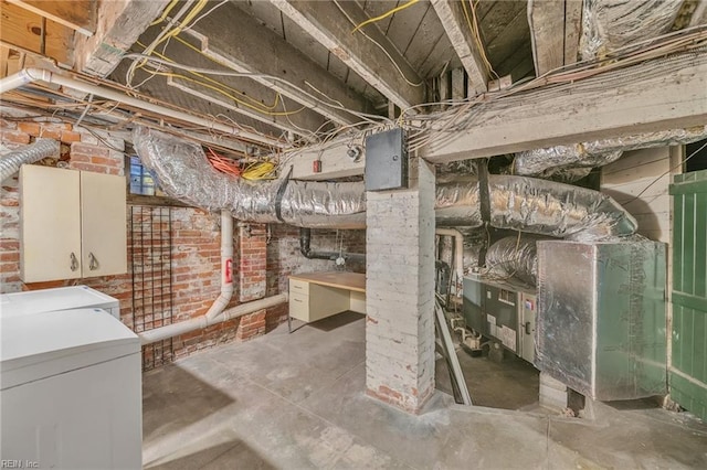 basement featuring independent washer and dryer and brick wall