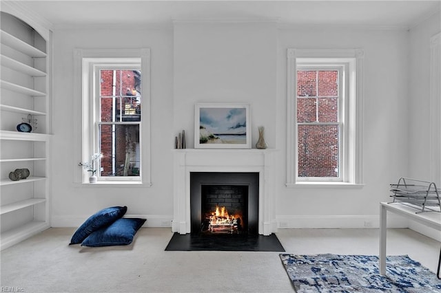 living room featuring built in shelves, ornamental molding, and carpet