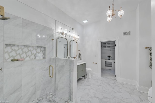 bathroom featuring vanity, a shower with door, and toilet