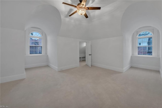 interior space with vaulted ceiling, light colored carpet, and ceiling fan