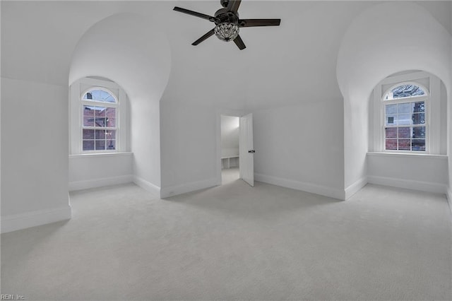 interior space with lofted ceiling, light colored carpet, and ceiling fan