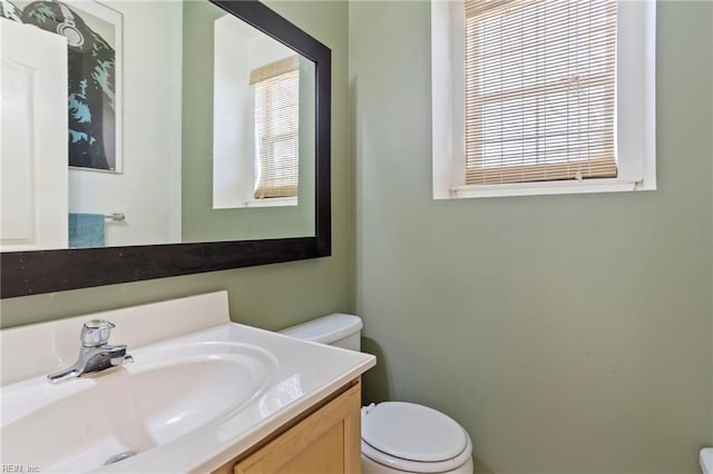 bathroom featuring vanity, toilet, and a wealth of natural light