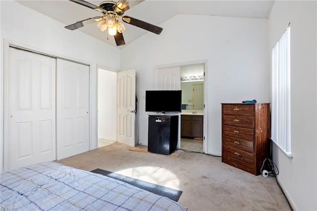 unfurnished bedroom featuring vaulted ceiling, light colored carpet, ensuite bath, and a closet