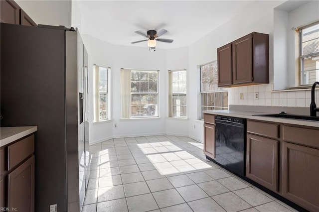 kitchen featuring black dishwasher, sink, decorative backsplash, light tile patterned floors, and stainless steel fridge with ice dispenser