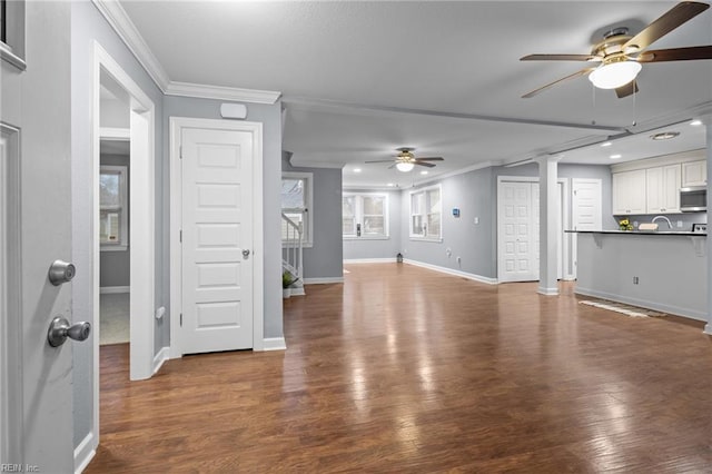 unfurnished living room with ornamental molding, sink, hardwood / wood-style floors, and ceiling fan