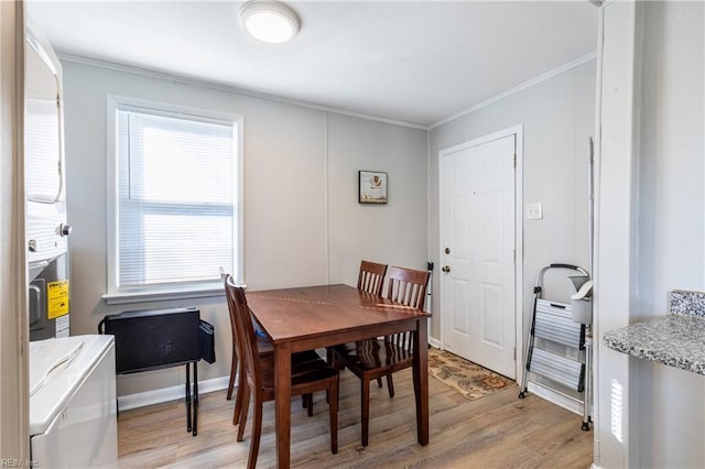 dining space featuring crown molding and light wood-type flooring