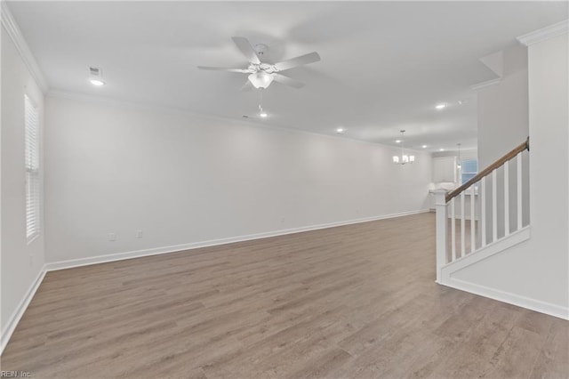 unfurnished room with ceiling fan with notable chandelier, light hardwood / wood-style flooring, and ornamental molding