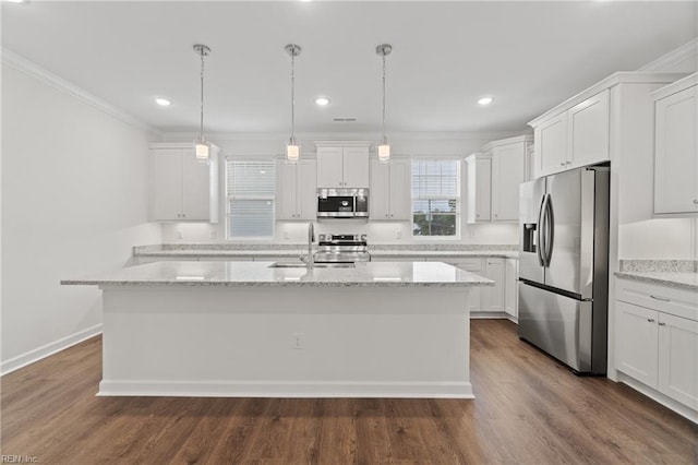 kitchen featuring light stone countertops, white cabinetry, appliances with stainless steel finishes, and a center island with sink