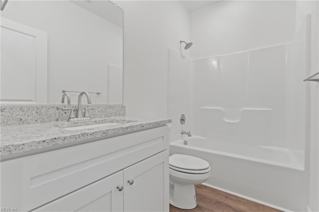 full bathroom featuring hardwood / wood-style flooring,  shower combination, toilet, and vanity