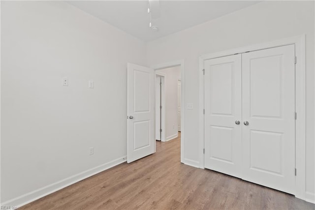 unfurnished bedroom with a closet and light hardwood / wood-style flooring