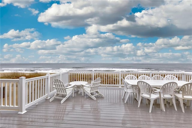 wooden terrace featuring a view of the beach and a water view