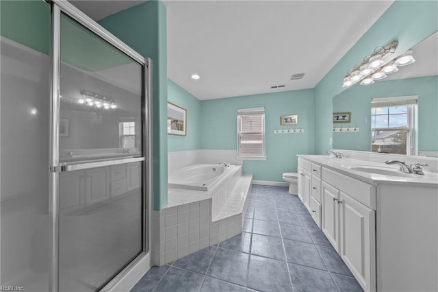 bathroom with a relaxing tiled tub, vanity, tile patterned flooring, and toilet