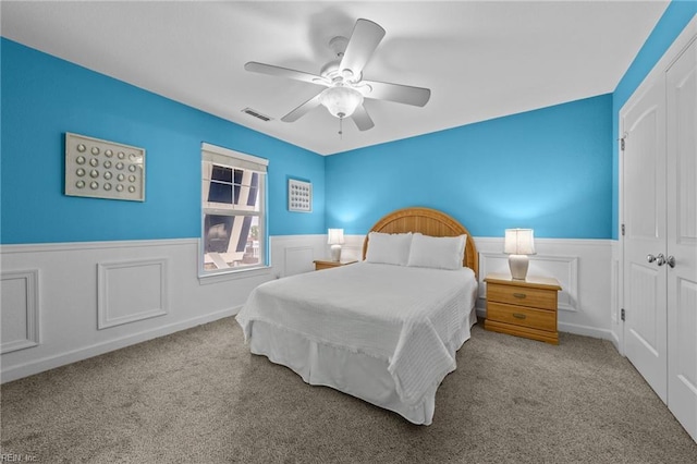 carpeted bedroom with ceiling fan and a closet