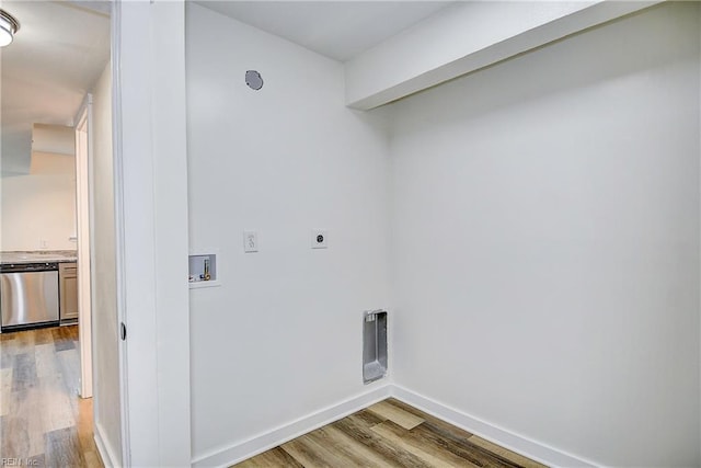 clothes washing area featuring electric dryer hookup, hookup for a washing machine, and light hardwood / wood-style flooring