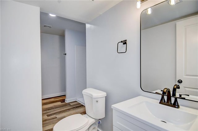 bathroom featuring vanity, toilet, and wood-type flooring