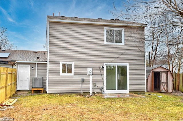 rear view of property featuring a yard and a storage unit